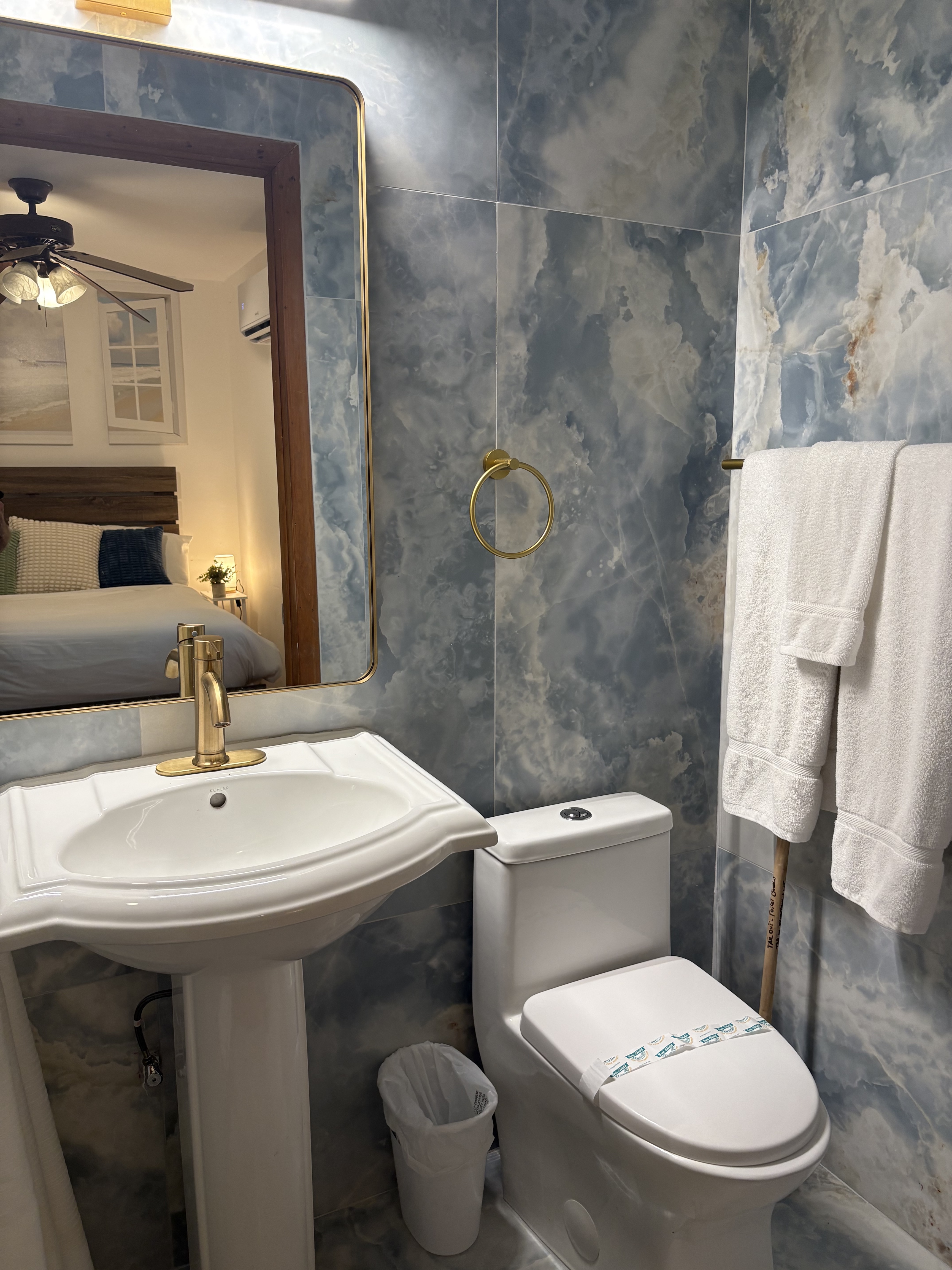 Blue stone bathroom vanity with brass mirror